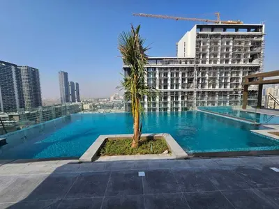 a palm tree on the roof of a building at Luxury Studio in JVC in Dubai