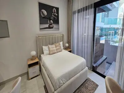 a bedroom with a bed and a large window at Luxury Studio in JVC in Dubai