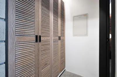 a wooden cabinet in a room with a wall at 1-Bedroom Apartment with Greenery & City Views in The Terraces in Dubai