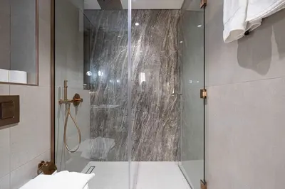 a shower with a glass door in a bathroom at Spacious 1BR with Modern Amenities in Westwood Grande JVC in Dubai