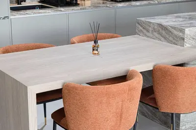 a kitchen with a wooden table with orange chairs at Spacious 1BR with Modern Amenities in Westwood Grande JVC in Dubai