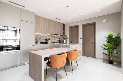 a kitchen with a wooden table and chairs at Spacious 1BR with Modern Amenities in Westwood Grande JVC in Dubai