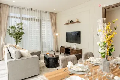 a living room with a table and a living room with a couch at Relax in Style with Outdoor Pool and Burj Khalifa Views Nearby in Dubai