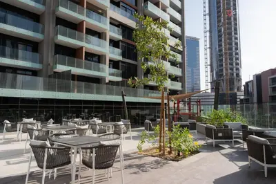 a patio with tables and chairs in front of a building at Relax in Style with Outdoor Pool and Burj Khalifa Views Nearby in Dubai