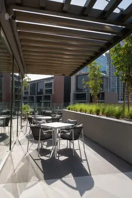 a patio with tables and chairs on a building at Relax in Style with Outdoor Pool and Burj Khalifa Views Nearby in Dubai