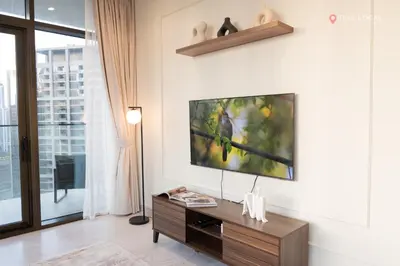 a living room with a flat screen tv on a wall at Relax in Style with Outdoor Pool and Burj Khalifa Views Nearby in Dubai