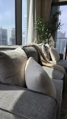 a couch with pillows on it in a living room at Relax in Style with Outdoor Pool and Burj Khalifa Views Nearby in Dubai