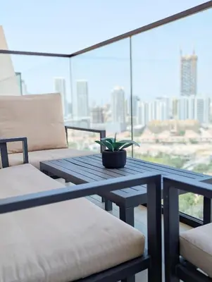 a patio table with a potted plant on a balcony at Modern Luxury Fully Furnished 1BH Apartment in Binghatt Nova JVC - Easy Access to JBR, Circle Mall & Dubai Hills Mall in Dubai