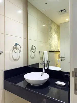 a bathroom with a sink and a mirror at Spacious 1BR - Balcony & Pool View - Capital Bay in Dubai
