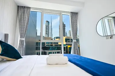 a bedroom with a large window with a large white bed at The Pad Burj Khalifa view 1Bd in Dubai