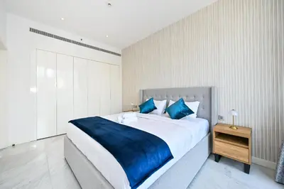 a bedroom with a large bed with a blue blanket at The Pad Burj Khalifa view 1Bd in Dubai