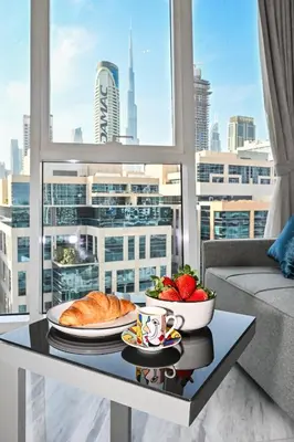 a table with a plate of bread and fruit on a table at The Pad Burj Khalifa view 1Bd in Dubai
