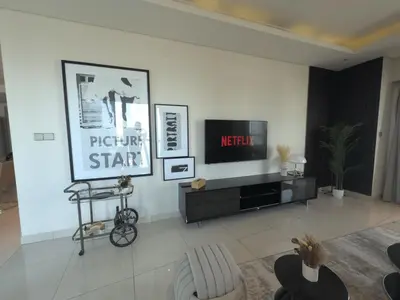 a living room with a tv on a white wall at HollywoodDXB Burj Khalifa View - 6Min To Dubai Mall in Dubai