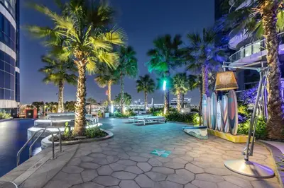 a courtyard with palm trees and a building at HollywoodDXB Burj Khalifa View - 6Min To Dubai Mall in Dubai