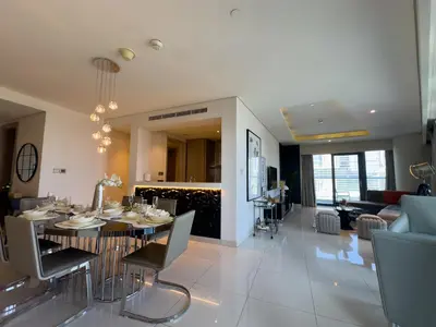 a dining room and living room with a table and chairs at HollywoodDXB Burj Khalifa View - 6Min To Dubai Mall in Dubai