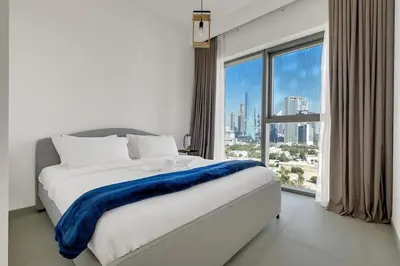 a bed in a room with a large window at Elegant 2BR by Dubai Mall in Dubai