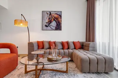 a living room with a couch and a horse painting on the wall at Elegant 2BR by Dubai Mall in Dubai