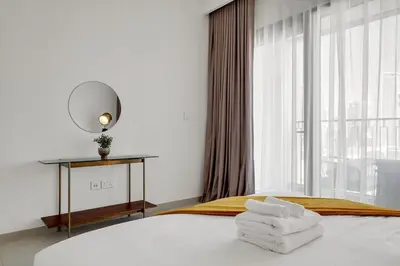 a white bedroom with a bed with towels on it at Elegant 2BR by Dubai Mall in Dubai
