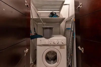 a small bathroom with a washing machine in a room at HAVN - Studio in Downtown, 10mins to Dubai Mall in Dubai