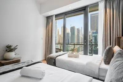 a hotel room with two beds and a large window at Dubai Marina View - 2BR APT with Pool & Gym in Dubai