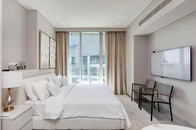 a white bedroom with a large bed and a tv at Great Apartments at Marina Star with City View in Dubai