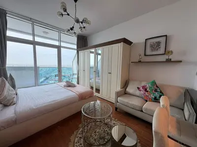 a living room with a bed and a couch at Cozy Studio Apartment Holiday Home l Perfect for Couples in Dubai