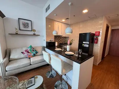 a kitchen and a living room with a couch at Cozy Studio Apartment Holiday Home l Perfect for Couples in Dubai