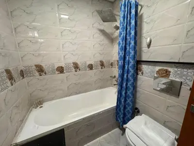 a bathroom with a white tub and a toilet at Cozy Studio Apartment Holiday Home l Perfect for Couples in Dubai