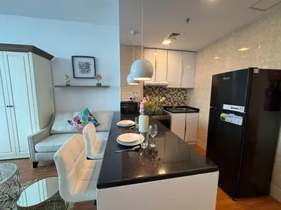a kitchen and living room with a black refrigerator at Cozy Studio Apartment Holiday Home l Perfect for Couples in Dubai