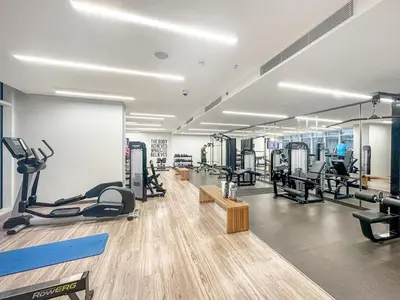 a gym with treadmills and machines in a room at Sea View 2BR Near Beach Marina Walk & Dining Spots in Dubai