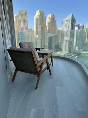 a chair on a balcony with a view of a city at Entire apartment in Dubai Marina in Dubai