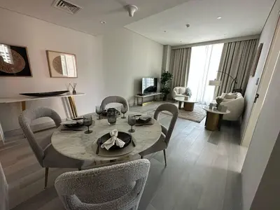 a living room with a dining room table and chairs at Entire apartment in Dubai Marina in Dubai