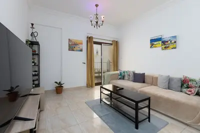 a living room with a couch and a table at Cozy 1BR Apartment in Lolena Tower, JVC - Allsopp & Allsopp in Dubai
