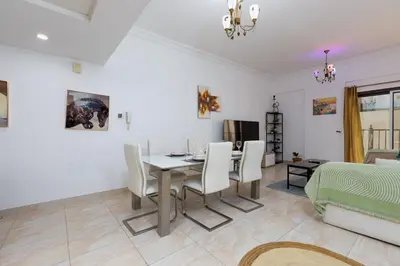 a dining room and living room with a table and chairs at Cozy 1BR Apartment in Lolena Tower, JVC - Allsopp & Allsopp in Dubai