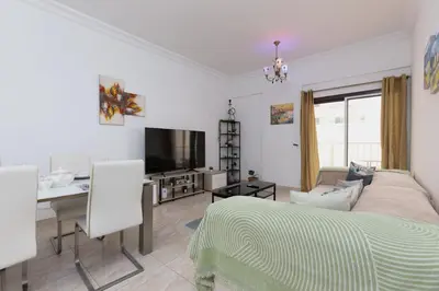 a living room with a bed and a desk and a television at Cozy 1BR Apartment in Lolena Tower, JVC - Allsopp & Allsopp in Dubai