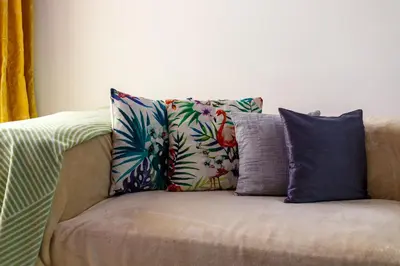 a couch with four pillows on top of it at Cozy 1BR Apartment in Lolena Tower, JVC - Allsopp & Allsopp in Dubai
