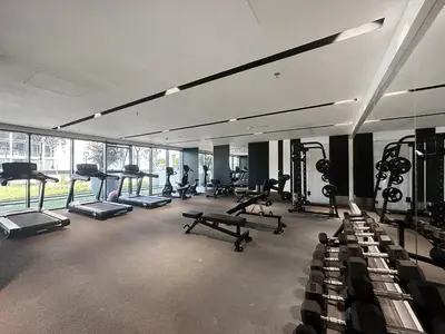 a gym with several treadmills and machines in it at FIRST CLASS 1BR Elegant Modern Retreat in Dubai