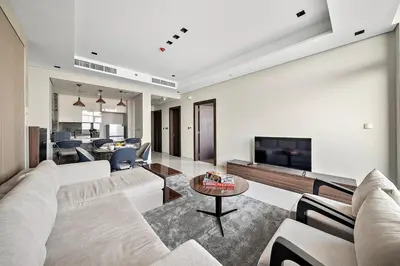 a living room with a couch and a tv at FIRST CLASS 1BR Elegant Modern Retreat in Dubai
