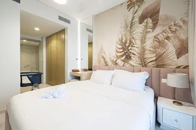 a bedroom with a large white bed with a wall mural at UrbanHomes - Luxury and Cozy 3BDR Apartment in Business Bay Canal View in Dubai
