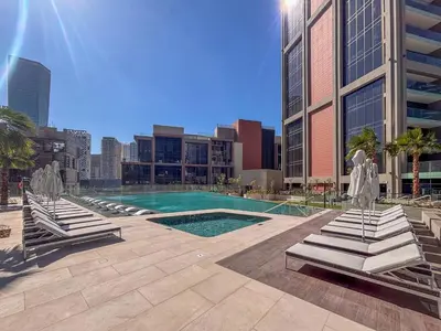 a swimming pool in a city with buildings at Frank Porter - Peninsula Five in Dubai