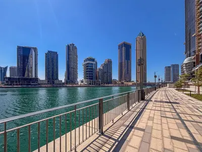 a bridge over a river in a city with tall buildings at Frank Porter - Peninsula Five in Dubai