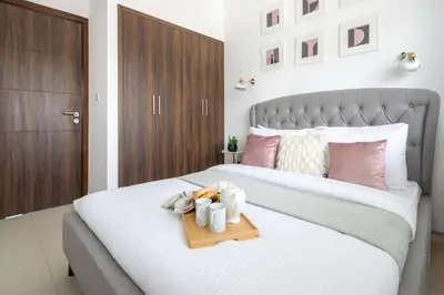 a bedroom with a bed with a tray on it at Frank Porter - Avencia 44 in ‘Ūd al Bayḑāʼ