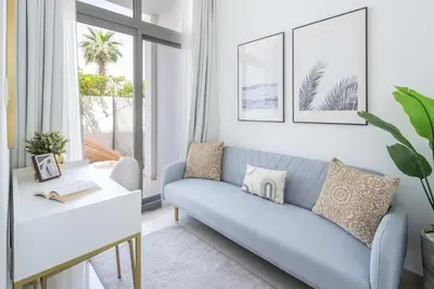 a living room with a blue couch and a table at Frank Porter - Avencia 44 in ‘Ūd al Bayḑāʼ