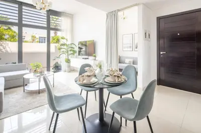 a dining room with blue chairs and a table at Frank Porter - Avencia 44 in ‘Ūd al Bayḑāʼ