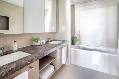 a bathroom with two sinks and a bath tub at Frank Porter - Boulevard Heights in Dubai