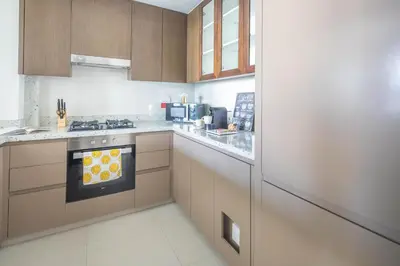a kitchen with wooden cabinets and a stove top oven at Frank Porter - Boulevard Heights in Dubai