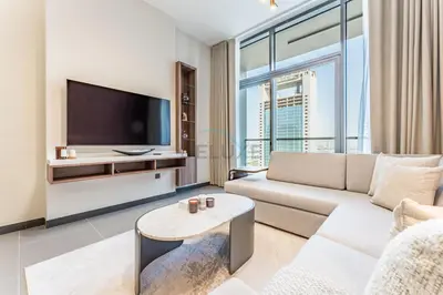 a living room with a couch and a tv at High-Rise 1BR with Lake and City Views and Minutes to Metro, MBL Royal, Jumeirah Lake Towers by Deluxe Holiday Homes in Dubai