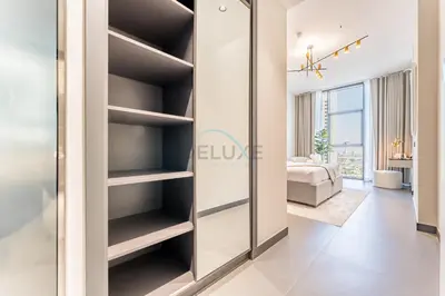 a room with a sliding door into a bedroom at High-Rise 1BR with Lake and City Views and Minutes to Metro, MBL Royal, Jumeirah Lake Towers by Deluxe Holiday Homes in Dubai