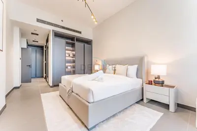 a white bedroom with a large white bed and a table at High-Rise 1BR with Lake and City Views and Minutes to Metro, MBL Royal, Jumeirah Lake Towers by Deluxe Holiday Homes in Dubai