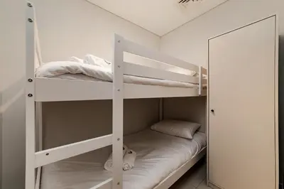 a white bunk bed in a room with a mirror at Luxury Apartment with Burj Khalifa Views - 5-Min Walk to Dubai Mall - Newly Upgraded - 10 people - Near Dubai Opera in Dubai